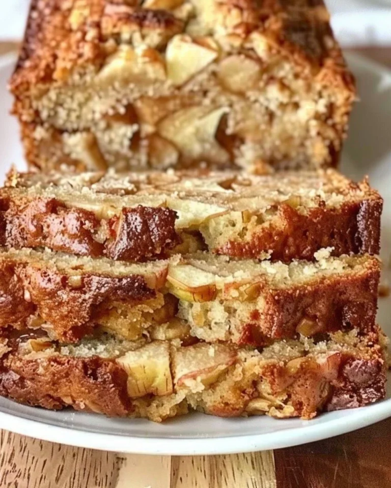 Freshly baked apple bread loaf with slices on a wooden cutting board